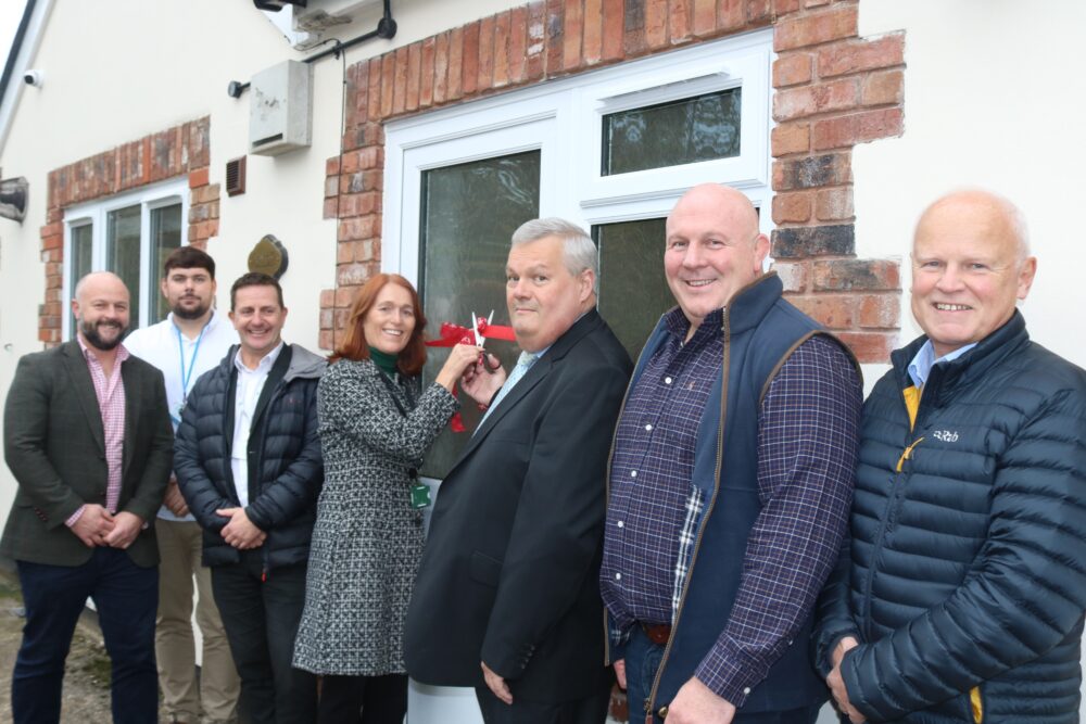 Melin CEO and Councillor cutting the ribbon on the door of the new home