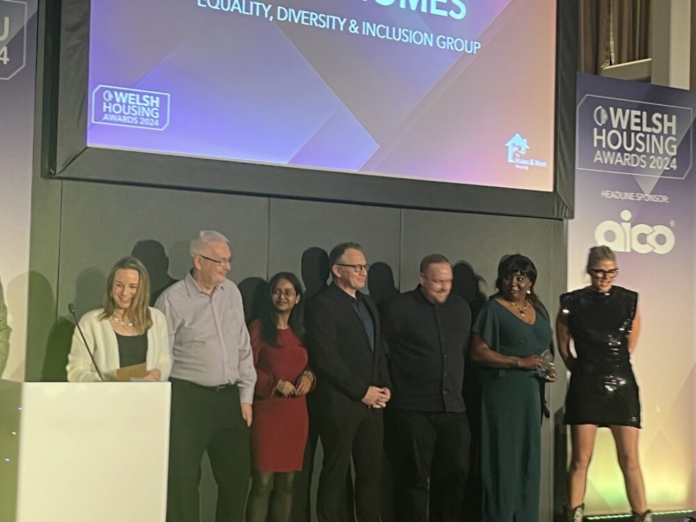 Grwp o bobl ar lwyfan mewn seremoni gwobrau