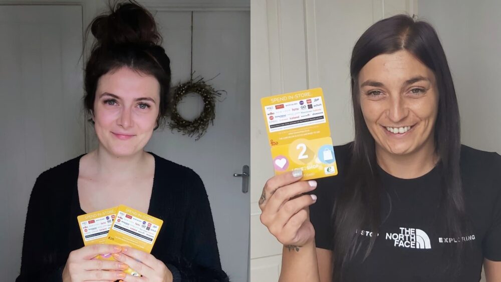 Two women holding shopping vouchers