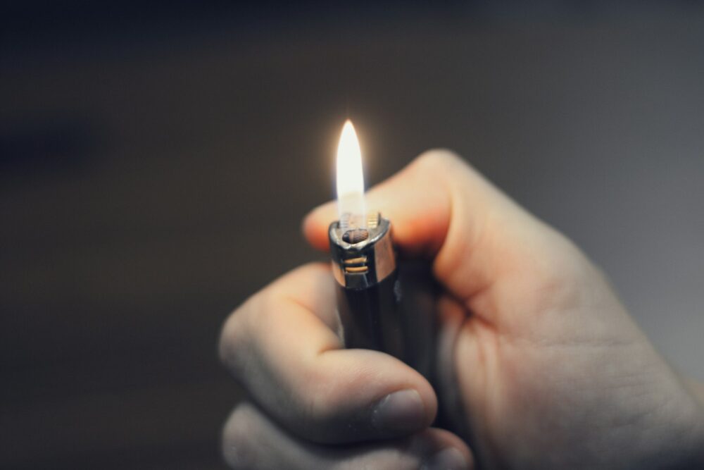 A hand holding a lit lighter