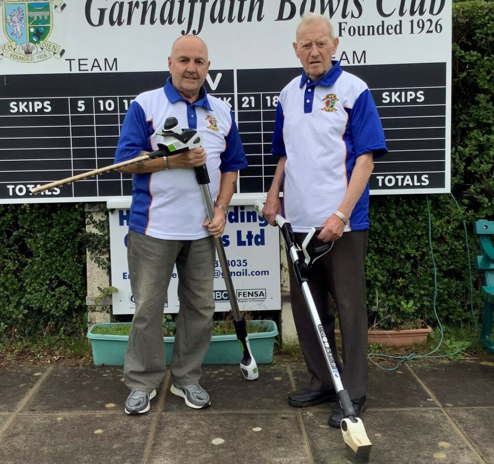 Two men holding gardening tools