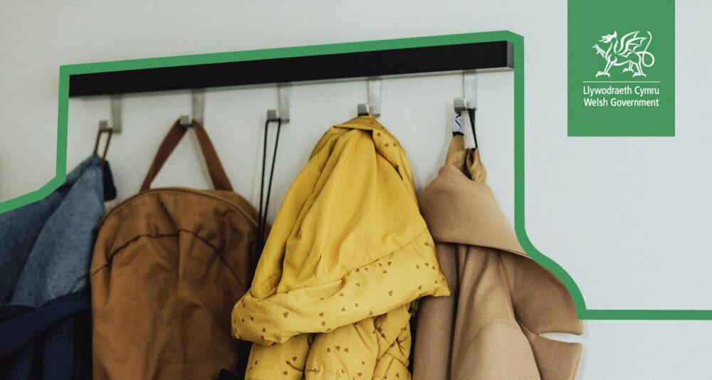 Coats on coat hooks featuring the Welsh Gov logo