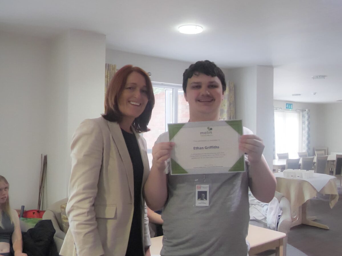 A young person receiving a certificate from Melin's CEO